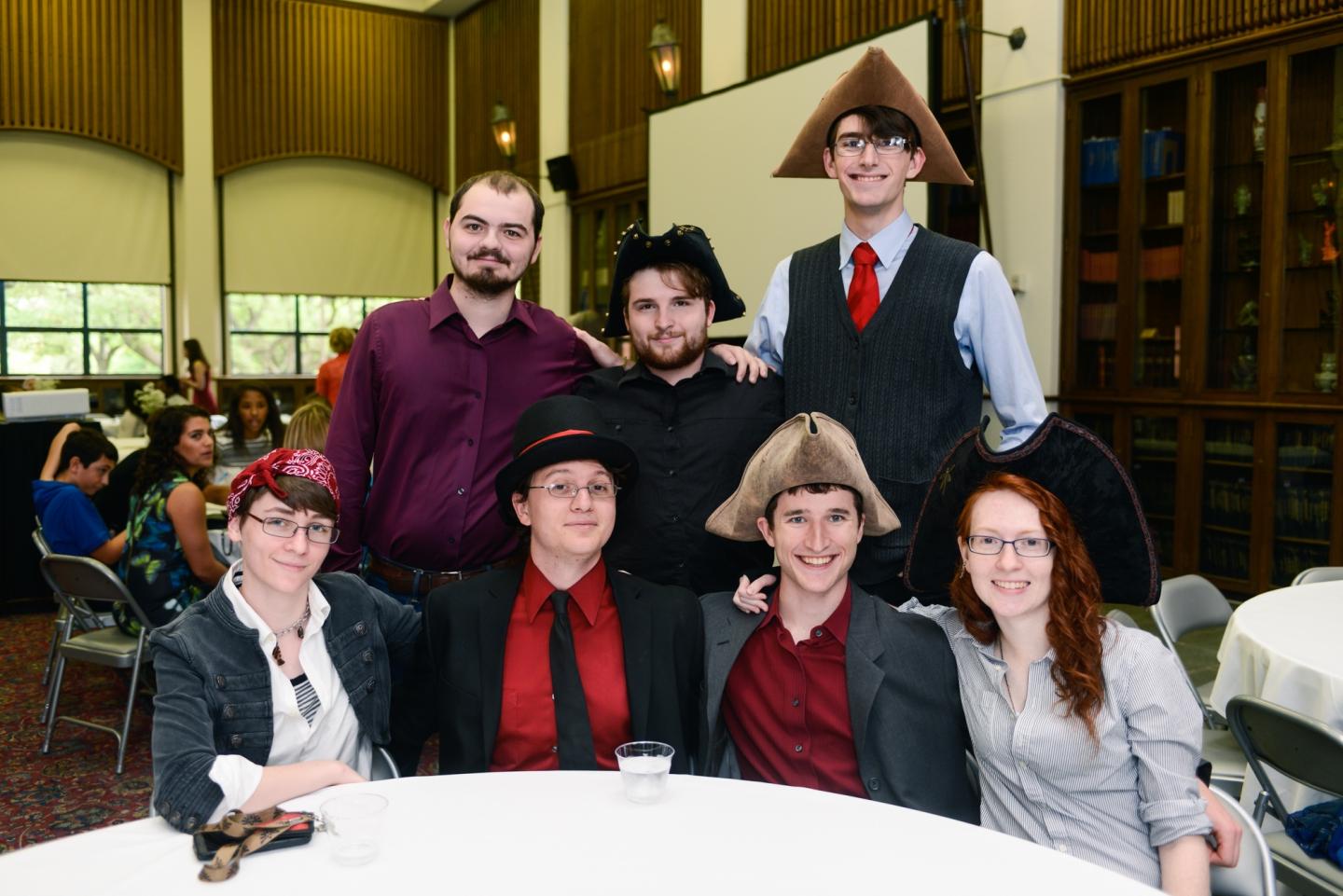 7 members of the Swashbucklers hall wear pirate hats at a leadership awards ceremony